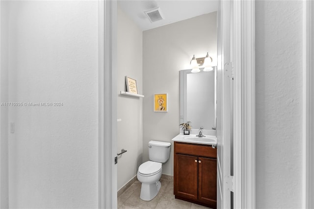 bathroom featuring toilet, vanity, and tile patterned floors