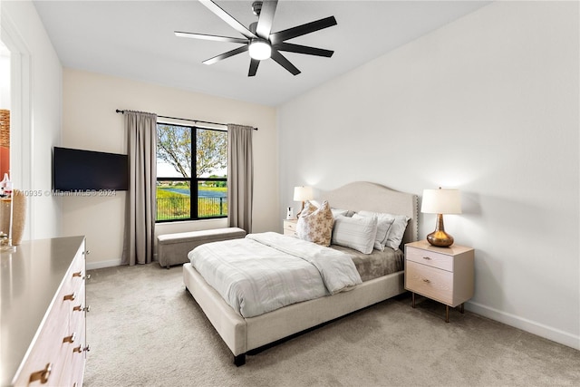 bedroom with ceiling fan and light carpet