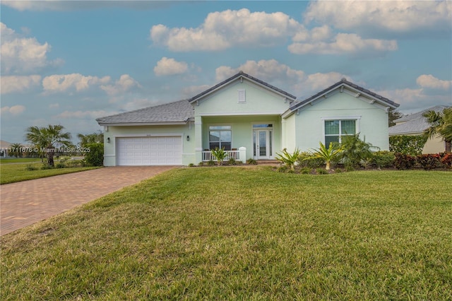 single story home with covered porch, a front yard, and a garage