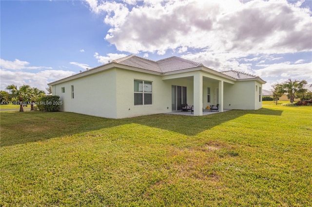 rear view of property with a lawn and a patio area