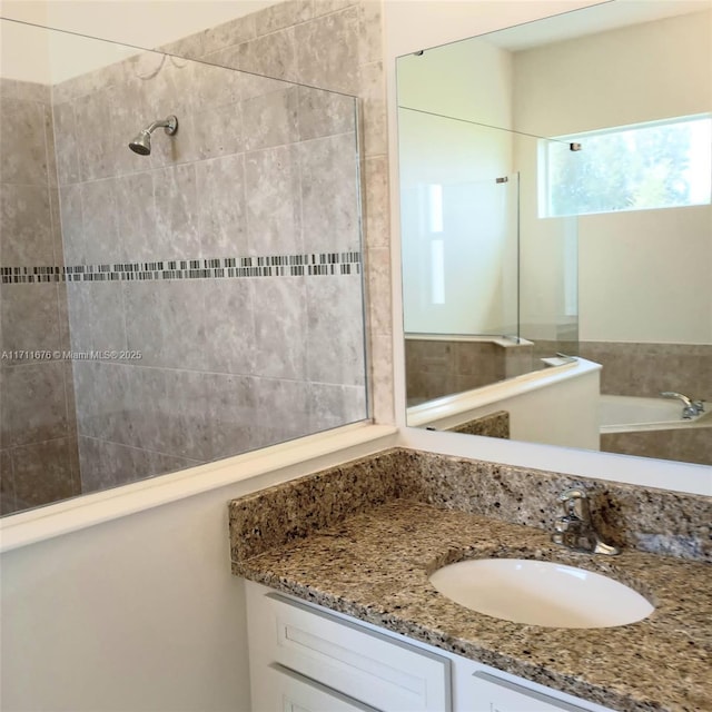 bathroom featuring a tile shower and vanity