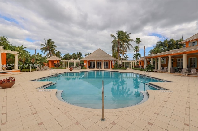 view of pool with a patio and an outdoor structure