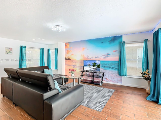 living room with a textured ceiling and light wood-type flooring