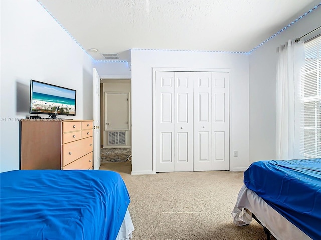 carpeted bedroom featuring a closet and a textured ceiling