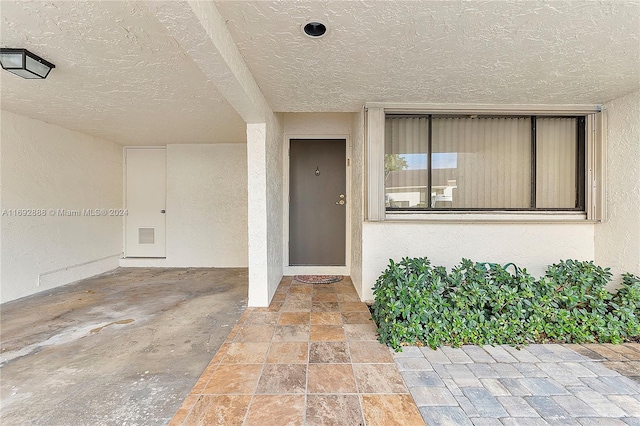 view of exterior entry with a patio area