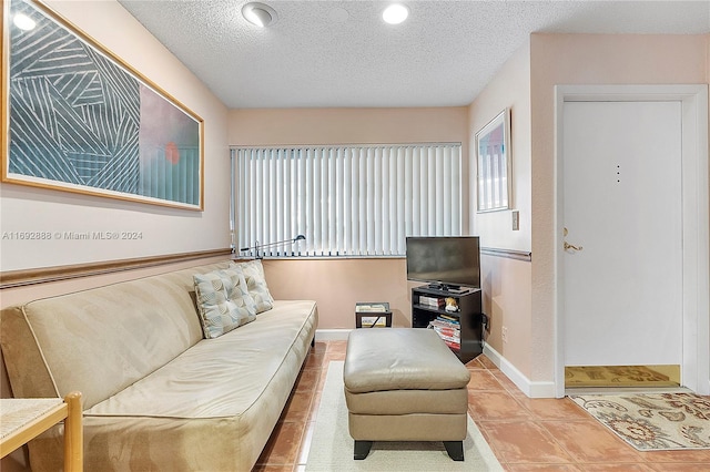 tiled living room featuring a textured ceiling