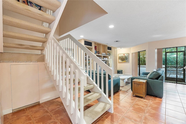 stairs with tile patterned flooring and a textured ceiling