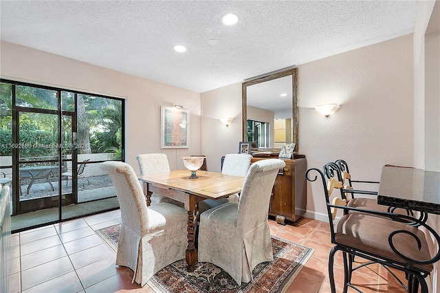 dining space with light tile patterned floors and a textured ceiling