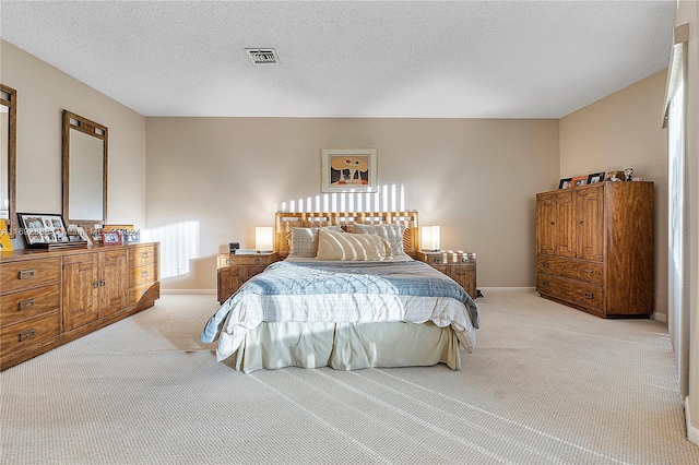 bedroom featuring light colored carpet and a textured ceiling