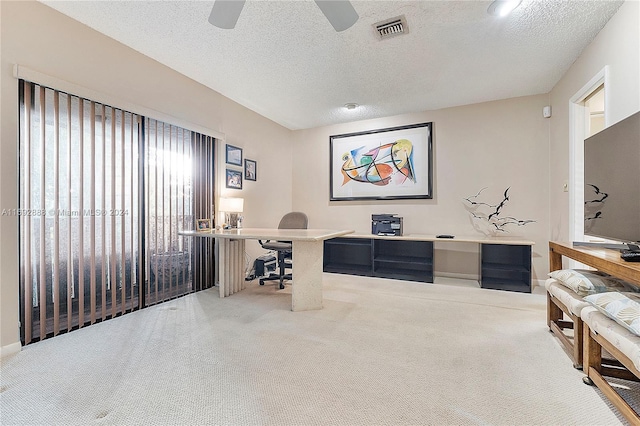 office area featuring ceiling fan, carpet floors, and a textured ceiling