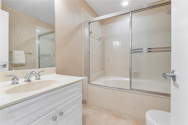 full bathroom with shower / bath combination with glass door, tile patterned flooring, vanity, and toilet