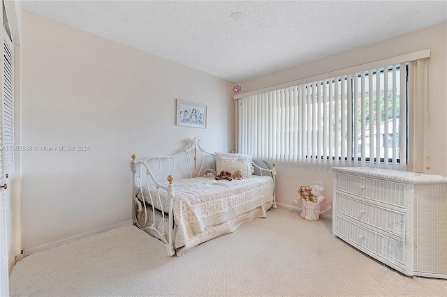 bedroom featuring a textured ceiling and carpet floors