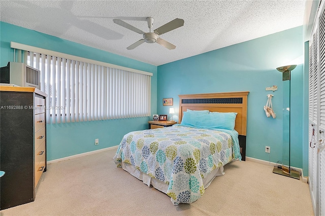 bedroom with light carpet, a textured ceiling, a closet, and ceiling fan