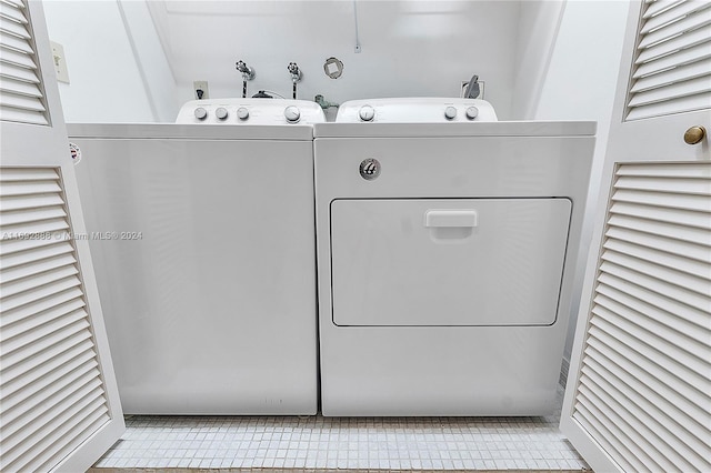 laundry room featuring separate washer and dryer and light tile patterned floors