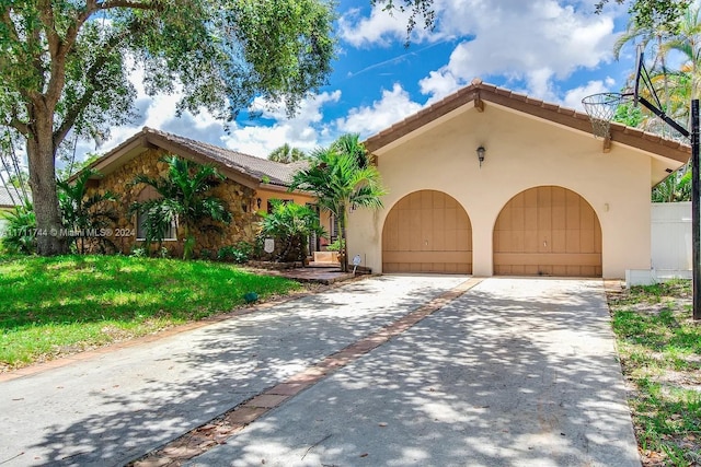 mediterranean / spanish-style home with a front lawn and a garage