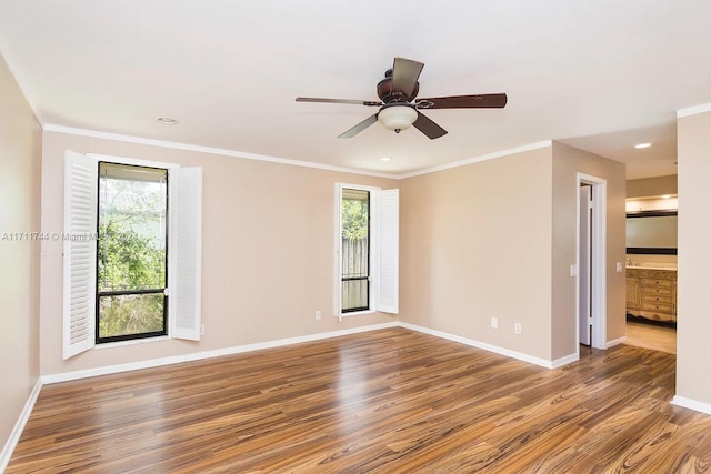 empty room featuring wood-type flooring, a wealth of natural light, crown molding, and ceiling fan