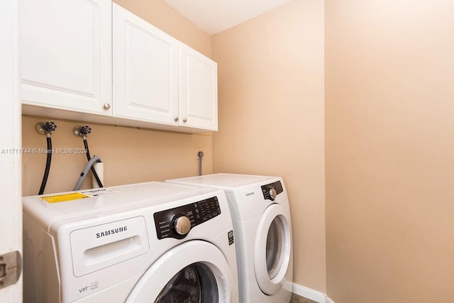 washroom featuring cabinets and washing machine and dryer