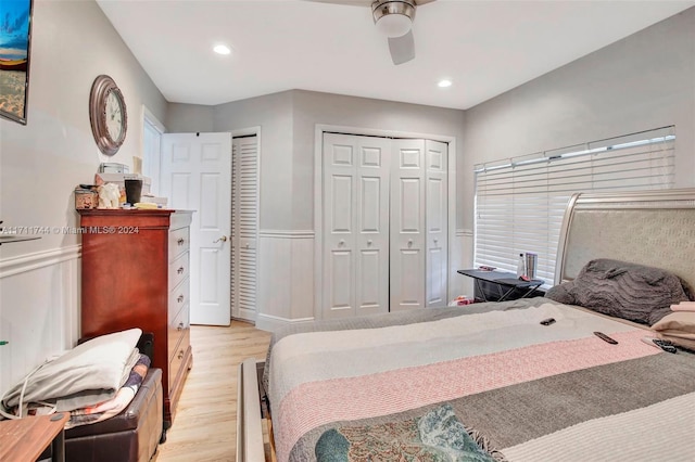 bedroom with two closets, light hardwood / wood-style floors, and ceiling fan