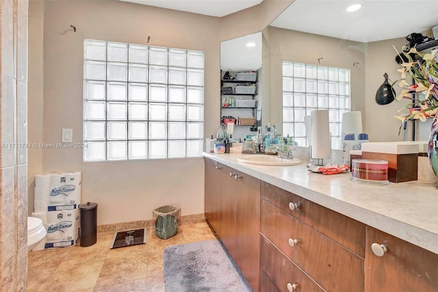 bathroom featuring tile patterned floors, vanity, a healthy amount of sunlight, and toilet