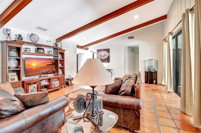 living room featuring vaulted ceiling with beams and plenty of natural light