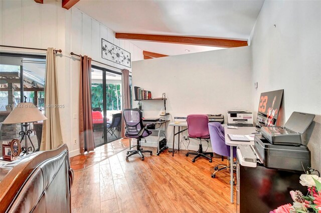 living room featuring vaulted ceiling with beams and light hardwood / wood-style flooring