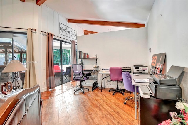 home office featuring light wood-type flooring and vaulted ceiling with beams