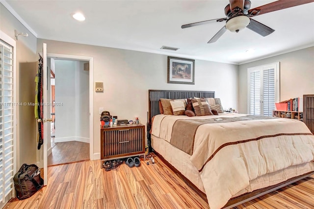 bedroom with multiple windows, light hardwood / wood-style flooring, and ceiling fan