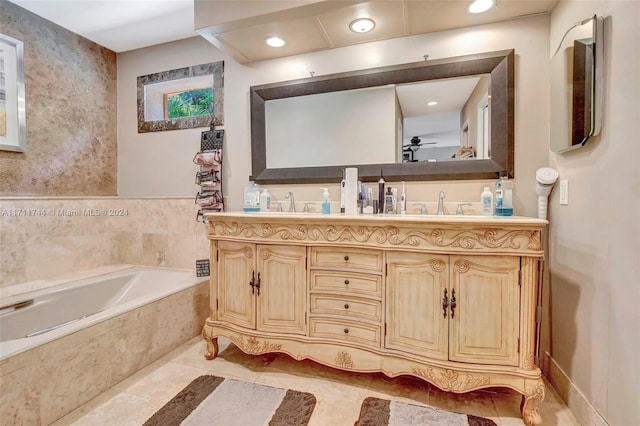 bathroom with tile patterned flooring, vanity, and a relaxing tiled tub