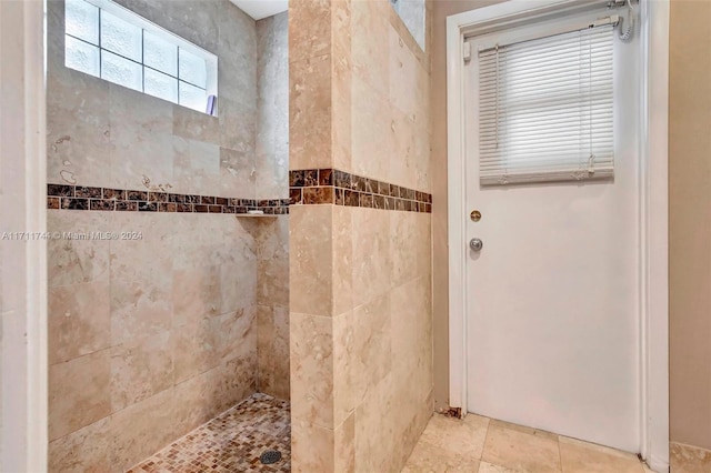 bathroom with tiled shower and tile patterned floors