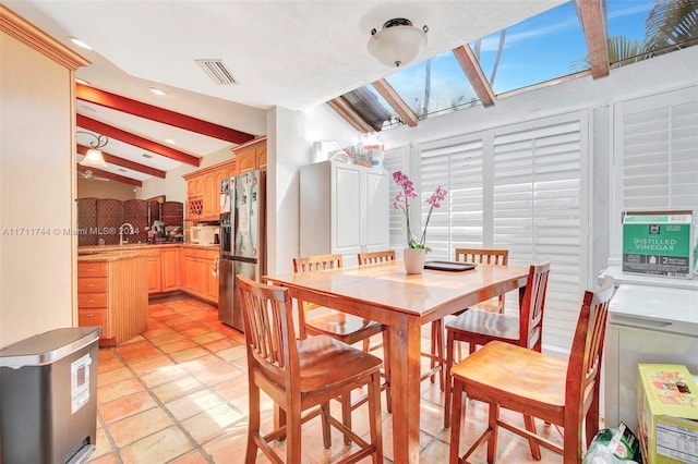 dining room with vaulted ceiling with beams