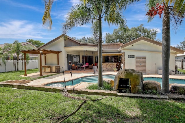 back of house with a lawn, ceiling fan, a fenced in pool, and a patio