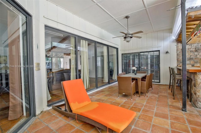 sunroom / solarium with a paneled ceiling and ceiling fan