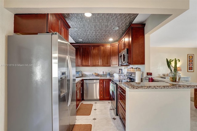 kitchen featuring light tile patterned floors, light stone counters, kitchen peninsula, and appliances with stainless steel finishes