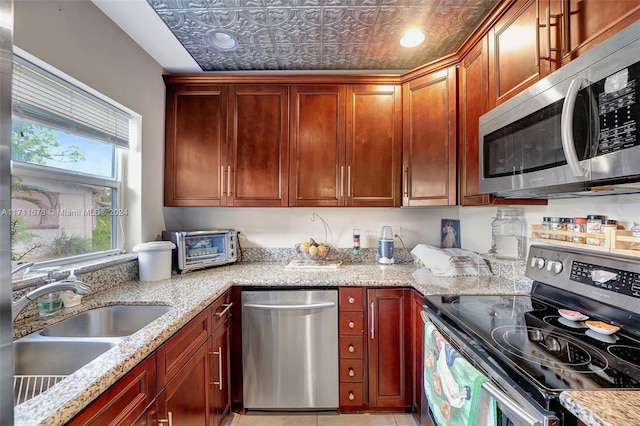 kitchen featuring light stone countertops, sink, and appliances with stainless steel finishes