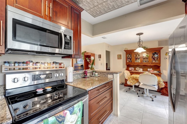 kitchen featuring light stone countertops, light tile patterned flooring, hanging light fixtures, and appliances with stainless steel finishes