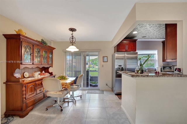 kitchen featuring plenty of natural light, light tile patterned floors, and stainless steel refrigerator with ice dispenser