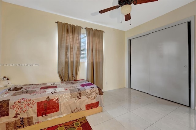 tiled bedroom featuring ceiling fan and a closet