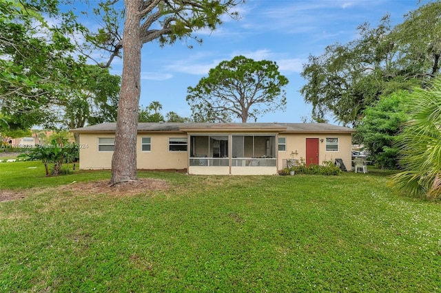 back of property with a lawn and a sunroom