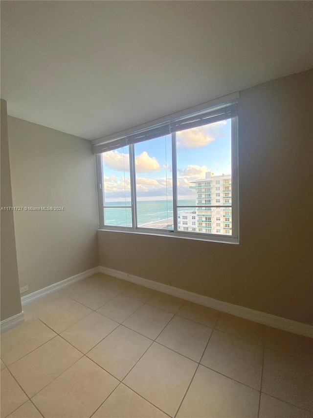 tiled empty room with a water view and plenty of natural light