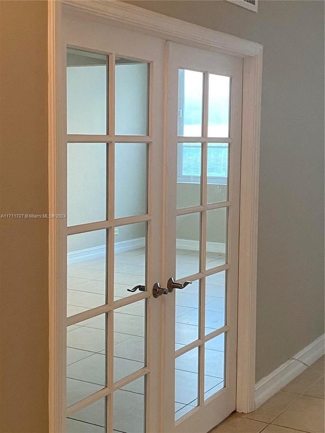 doorway to outside with tile patterned floors and french doors