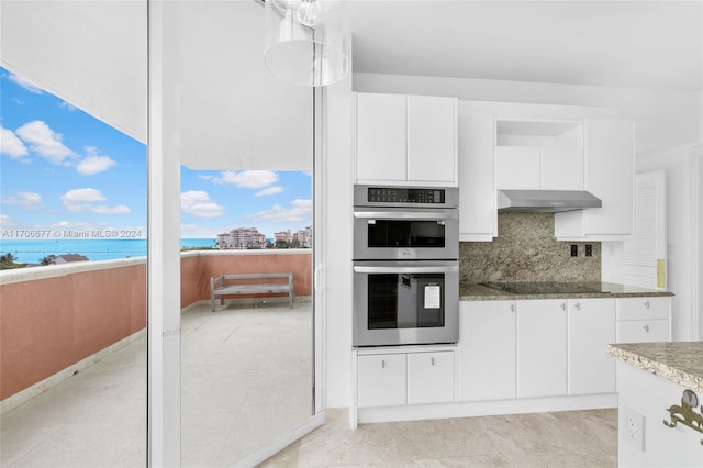 kitchen with ventilation hood, double oven, black electric cooktop, decorative backsplash, and white cabinets