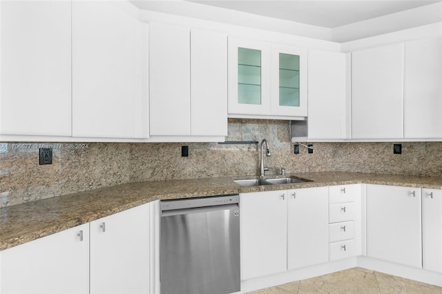 kitchen with dishwasher, white cabinets, sink, decorative backsplash, and dark stone countertops