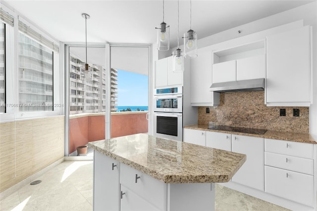 kitchen with white cabinets, decorative light fixtures, black electric stovetop, and double oven