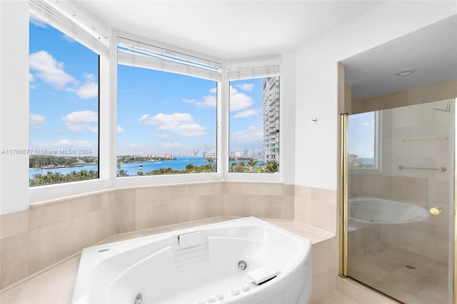 bathroom featuring a water view and shower with separate bathtub