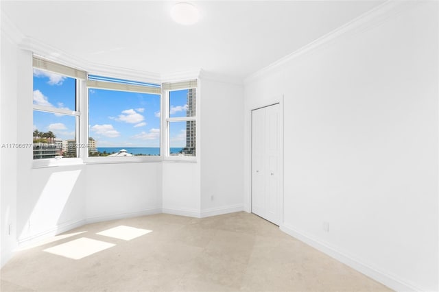 spare room featuring crown molding and a water view