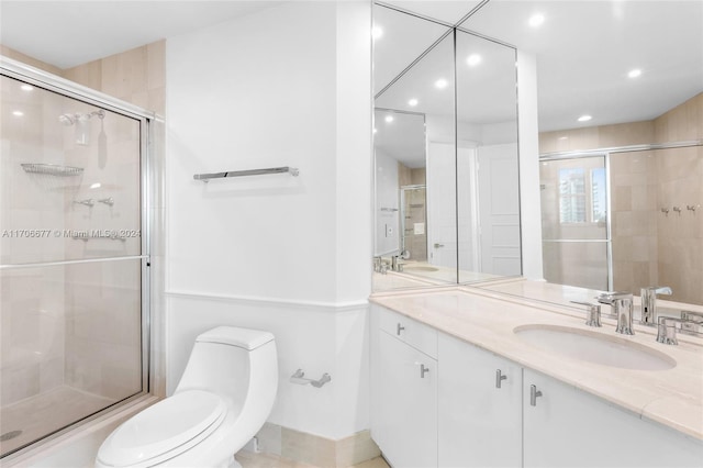 bathroom featuring vanity, toilet, and a shower with shower door