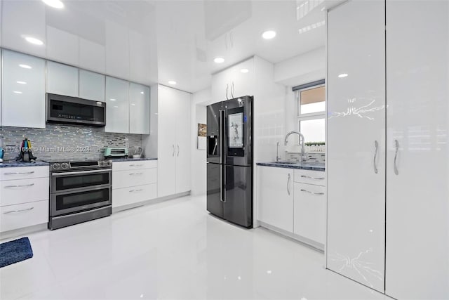 kitchen with sink, stainless steel appliances, white cabinets, backsplash, and light tile patterned flooring