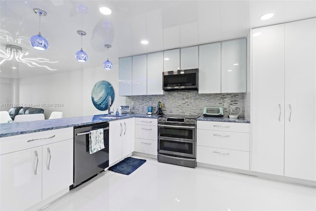 kitchen with pendant lighting, decorative backsplash, white cabinetry, and appliances with stainless steel finishes