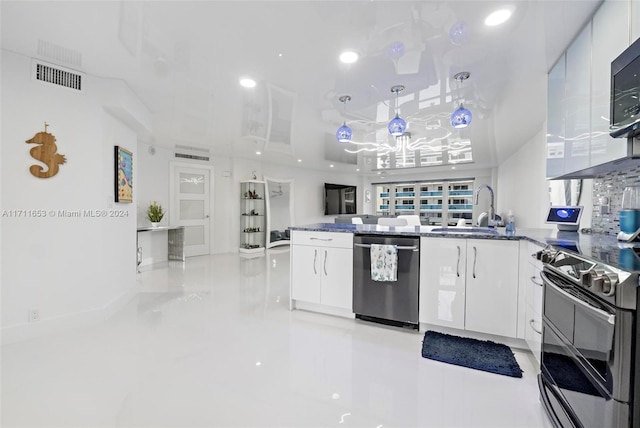 kitchen featuring white cabinets, appliances with stainless steel finishes, hanging light fixtures, and sink