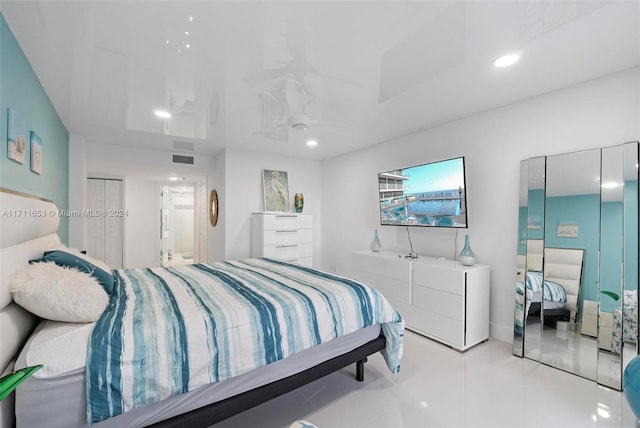 bedroom with light tile patterned floors, ensuite bath, and a closet